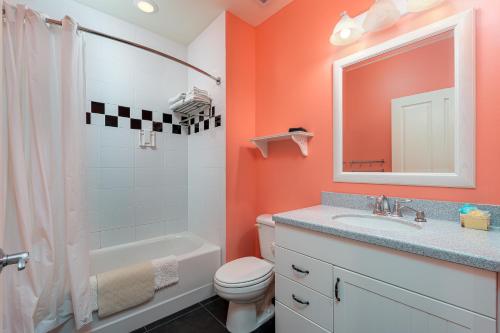 a bathroom with a toilet and a sink and a mirror at Harbour House at the Inn 313 in Fort Myers Beach