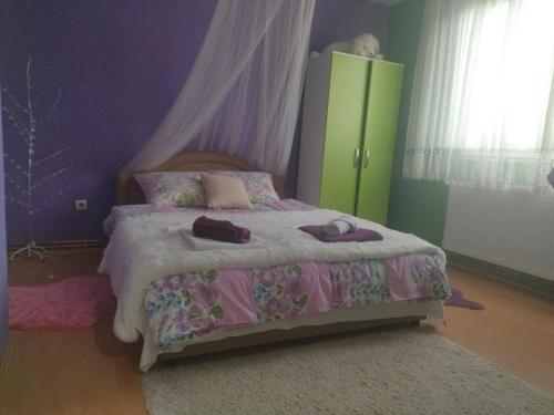 a bedroom with a bed with pink and purple walls at Apartman i sobe Milica Vrnjacka Banja in Vrnjci
