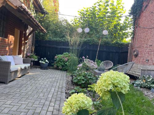 a patio with chairs and flowers in a backyard at Weberhof-Münster 2 in Münster