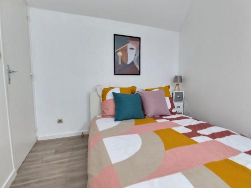 - une chambre avec un lit et une couverture colorée dans l'établissement Duplex Le Cachou : 10 min Aéroport de Roissy CDG - Astérix - Paris, à Moussy-le-Vieux