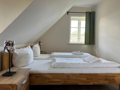 - une chambre avec 2 lits et une fenêtre dans l'établissement Mühlenhaus 3, à Wrixum