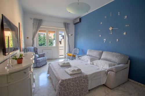 uma sala de estar com um sofá e uma parede azul em Home Bernadette em Roma