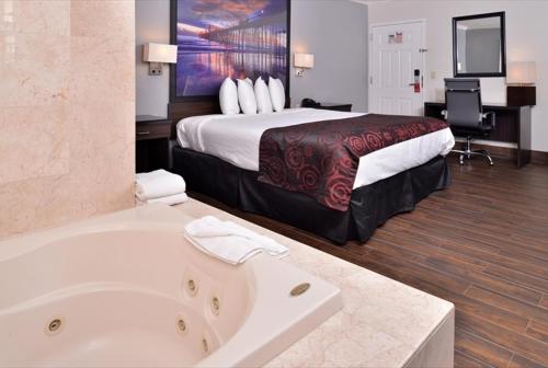 a hotel room with a bed and a bath tub at Americas Best Value Inn Hollywood in Los Angeles