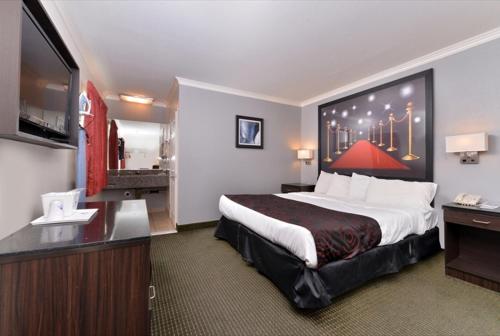 a hotel room with a large bed and a flat screen tv at Americas Best Value Inn Hollywood in Los Angeles