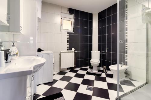 a bathroom with a black and white checkered floor at Green Art House in Kovilovo
