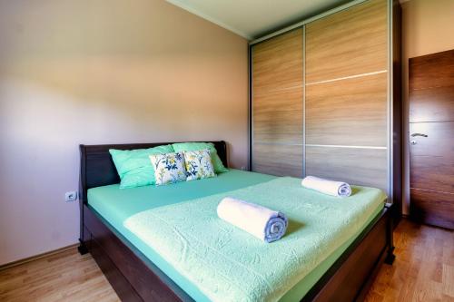 a bedroom with a bed with two towels on it at Green Art House in Kovilovo