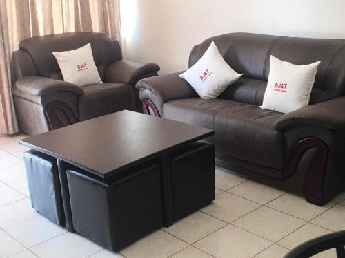 a living room with two couches and a coffee table at BJ&T Vacation Homes in Kasane