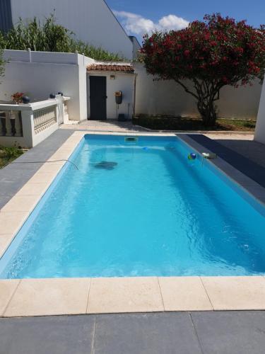 une grande piscine bleue devant une maison dans l'établissement Adorable Romantique Maison d'hôte, piscine, wifi 4G, proche BEZIERS, à Cers