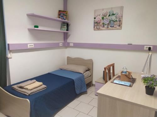 a small bedroom with a bed and a desk at La Quiete in Senna Comasco