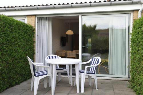 a white table and chairs on a patio at Hotel Balka Strand in Neksø