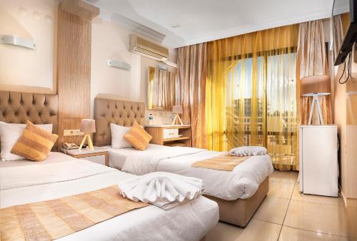 ディディムにあるTemple Miletos Spa Hotelのベッド2台と窓が備わるホテルルームです。