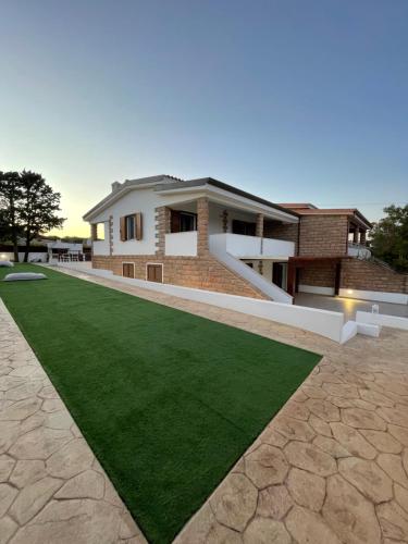 a house with a green lawn in front of it at Casa Miele in Santa Lucia
