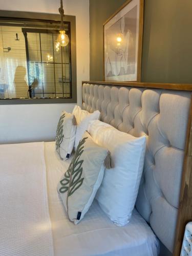a bed with three pillows on it in a room at Liman Hotel Gümüslük - Adult Only in Bodrum City
