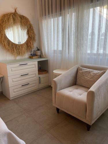 a living room with a couch and a mirror at Liman Hotel Gümüslük - Adult Only in Bodrum City