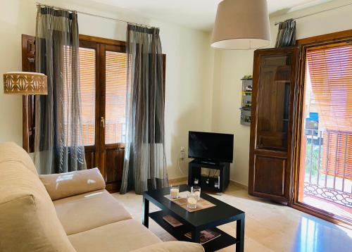 ein Wohnzimmer mit einem Sofa und einem Tisch in der Unterkunft La Fonda del Arco in Guadix