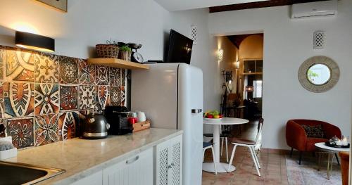 a kitchen with a refrigerator and a dining room at Casa Victoria in Olhão