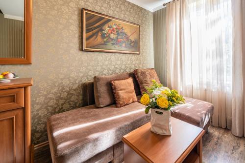a living room with a couch and a table with flowers at Videviku Villa Apartments in Tallinn