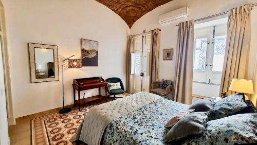 - une chambre avec un lit, un bureau et un miroir dans l'établissement Casa Victoria, à Olhão