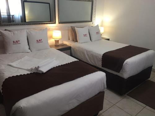 2 Betten in einem nebeneinander liegenden Hotelzimmer in der Unterkunft BJ&T Vacation Homes in Kasane