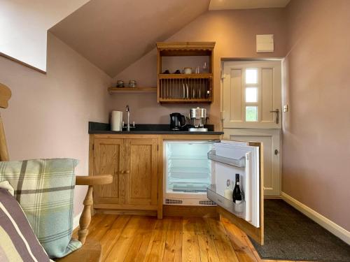 a small kitchen with a counter and a refrigerator at The Hayloft, Exmoor in Withypool