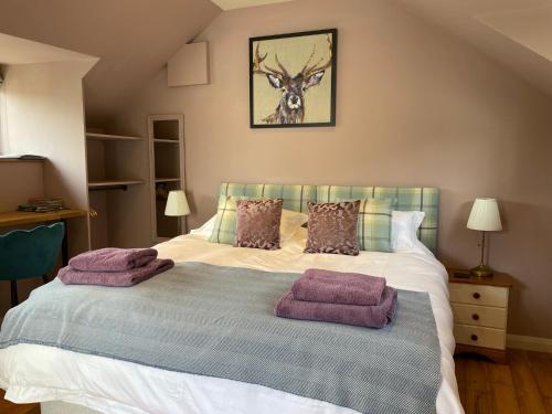 Withypool的住宿－The Hayloft, Exmoor，一间卧室配有一张床,上面有两条紫色毛巾