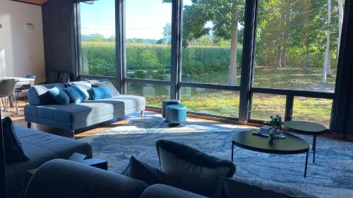 a living room with a couch and a large window at Hakobune Niseko - 8-room Chalets & 2-room Apartments in Niseko