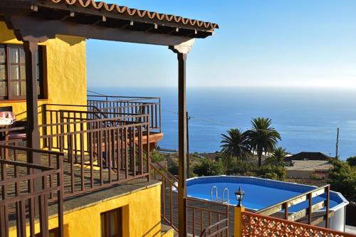 - un balcon offrant une vue sur une maison avec piscine dans l'établissement Villa Las Flores by Rural La Palma, à Tijarafe