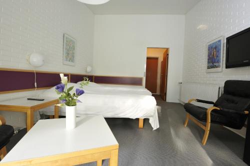 a hotel room with a bed and a table with flowers at Hotel Balka Strand in Neksø