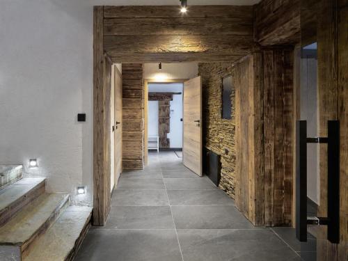 什切爾克的住宿－Poczuj Spokój Szczyrk - Free Sauna & Balia，走廊设有木墙和瓷砖地板