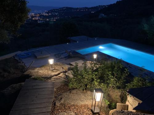 a swimming pool lit up at night with lights at Villa de charme à Ajaccio in Ajaccio