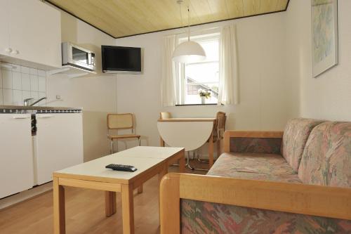 a living room with a couch and a table at Hotel Balka Strand in Neksø