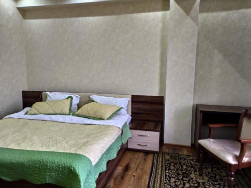 um quarto com uma cama e uma cadeira em Bahri Tojik Resort & Spa em Kairakum