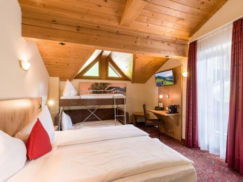 een slaapkamer met 2 bedden in een kamer met houten plafonds bij Alpengasthof Gruberhof in Söll