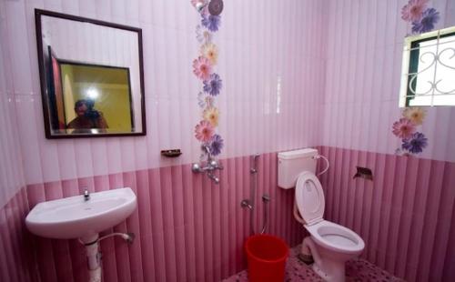 Baño rosa con lavabo y aseo en PARVATI MANDREM, en Mandrem