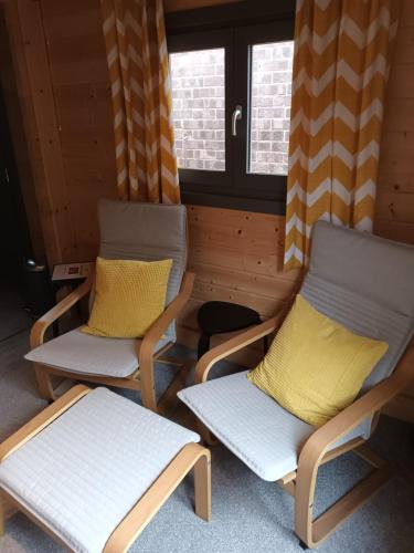 two chairs with yellow pillows sitting in a room at Nancy's Cabin in Mosborough