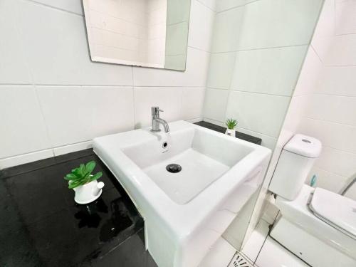 La salle de bains blanche est pourvue d'un lavabo et de toilettes. dans l'établissement C 1-5 Pax Cozy home Studio 3Bed WIFI&TV Trefoil Setia Alam SCCC, à Setia Alam