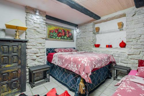 a bedroom with a bed and a stone wall at Videviku Villa Apartments in Tallinn