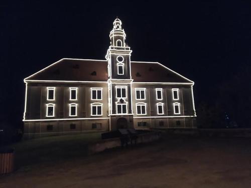 a large white building with a clock tower at night at Apartman Ana 1 in Valpovo