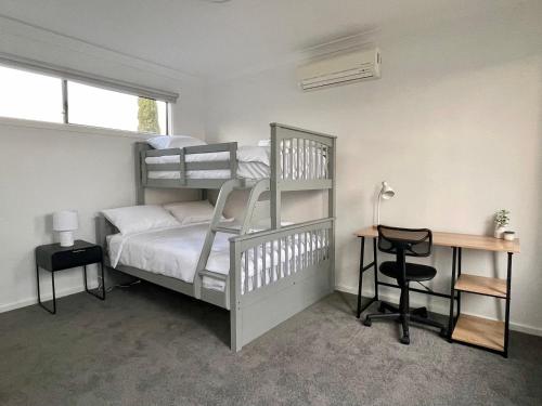 a bedroom with a bunk bed with a desk and a desk at Bliss on the Bay Cheerful townhouse in Torquay in Torquay