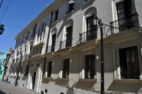 ein großes weißes Gebäude mit Fenstern und einem Straßenlicht in der Unterkunft Student's Housing Republica in Santiago