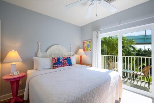 a bedroom with a bed and a balcony at Harbour House at the Inn 315 in Fort Myers Beach