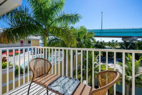 two chairs on a balcony with a view of the ocean at Harbour House at the Inn 315 in Fort Myers Beach