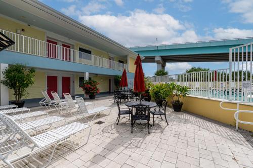 an outdoor patio with chairs and tables and umbrellas at Harbour House at the Inn 315 in Fort Myers Beach