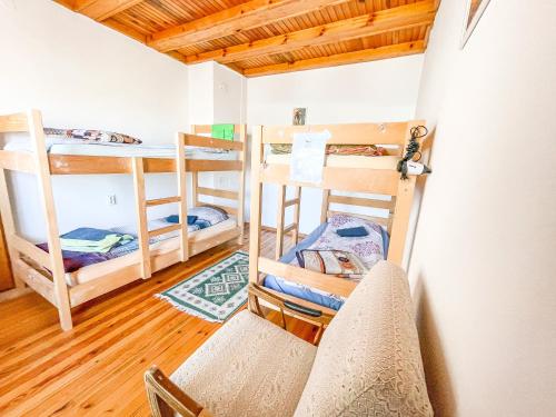 Cette chambre comprend 3 lits superposés et une chaise. dans l'établissement Gorica Guest House, à Mavrovi Anovi
