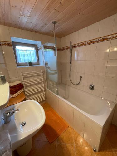 W łazience znajduje się wanna, umywalka i prysznic. w obiekcie Ferienwohnung Rauch w mieście Schwendau
