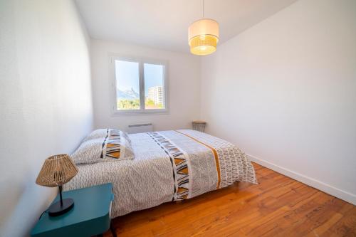 1 dormitorio con cama y ventana en 3 chambres - 6 couchages - Vue imprenable, en Saint-Martin-dʼHères