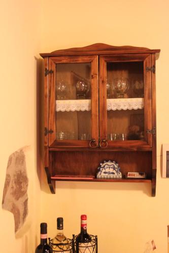 a wooden cabinet hanging on a wall with dishes in it at Casa Vacanze Le Antiche Pietre in Ortignano Raggiolo