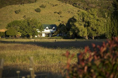 a house in the middle of a field at Jacaranda Lodge in Coromandel Town