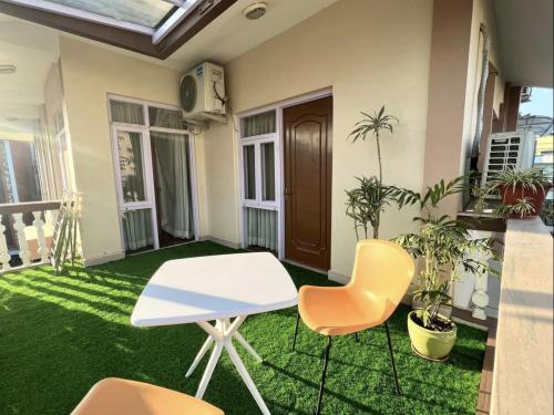 a room with a table and chairs and grass at Kibu Home in Kathmandu