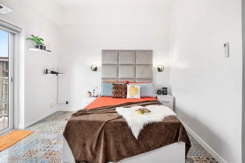 1 dormitorio blanco con 1 cama grande con manta naranja en Hyllia by J&J (Near Airport . Wifi . Netflix ), en Pusok
